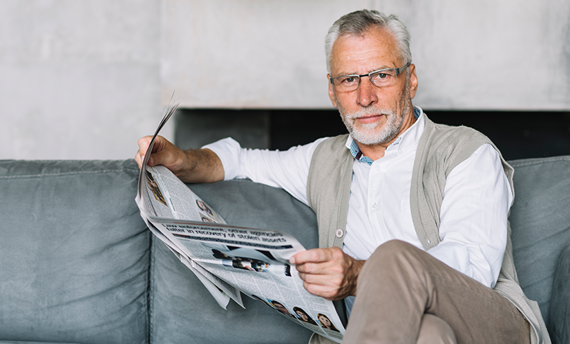 elderly-man-sitting-sofa-reading-newspaper